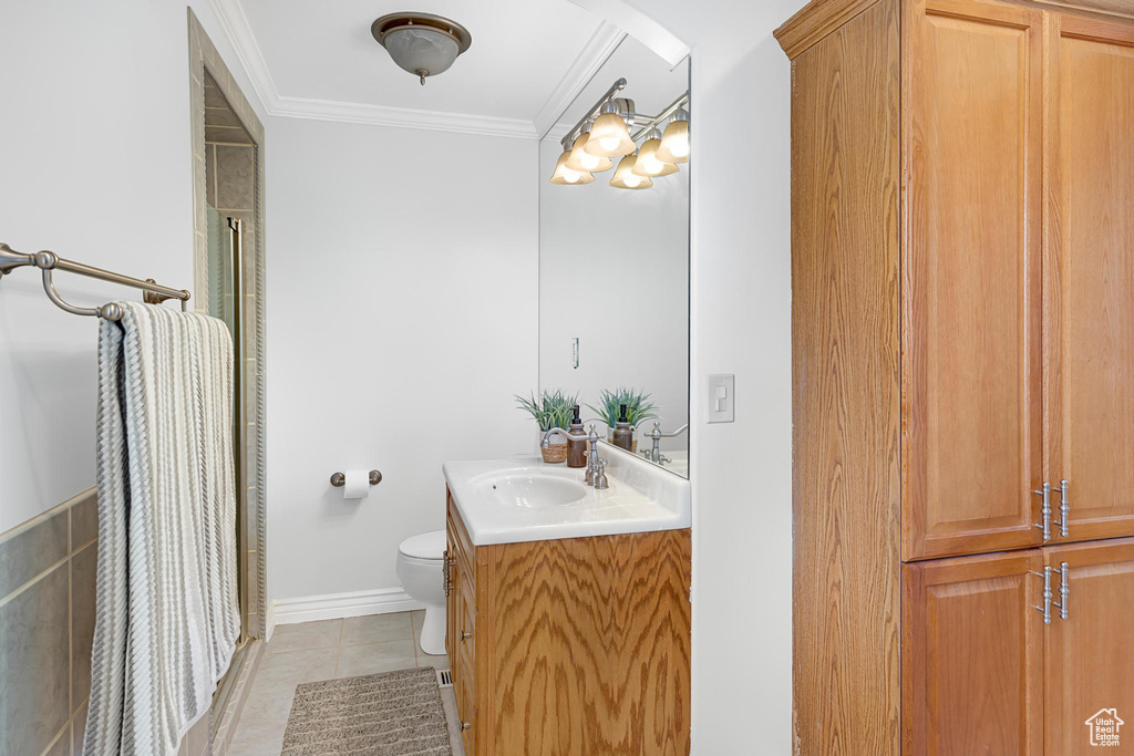 Full bathroom featuring tile patterned floors, toilet, vanity, crown molding, and a shower with shower curtain