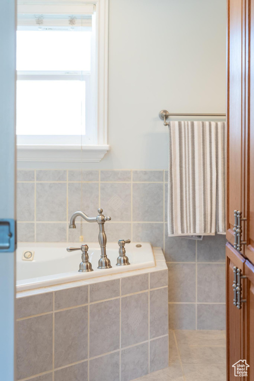 Full bathroom featuring a bath, tile walls, and tile patterned flooring