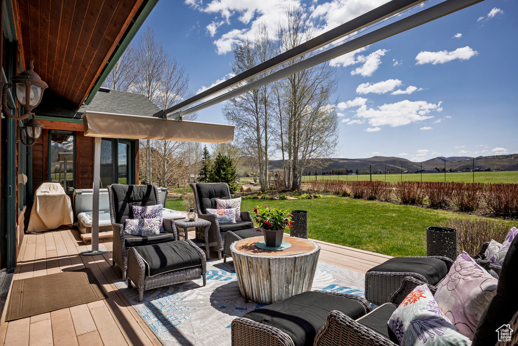 View of patio / terrace featuring an outdoor hangout area, a deck with mountain view, and a view of rural / pastoral area