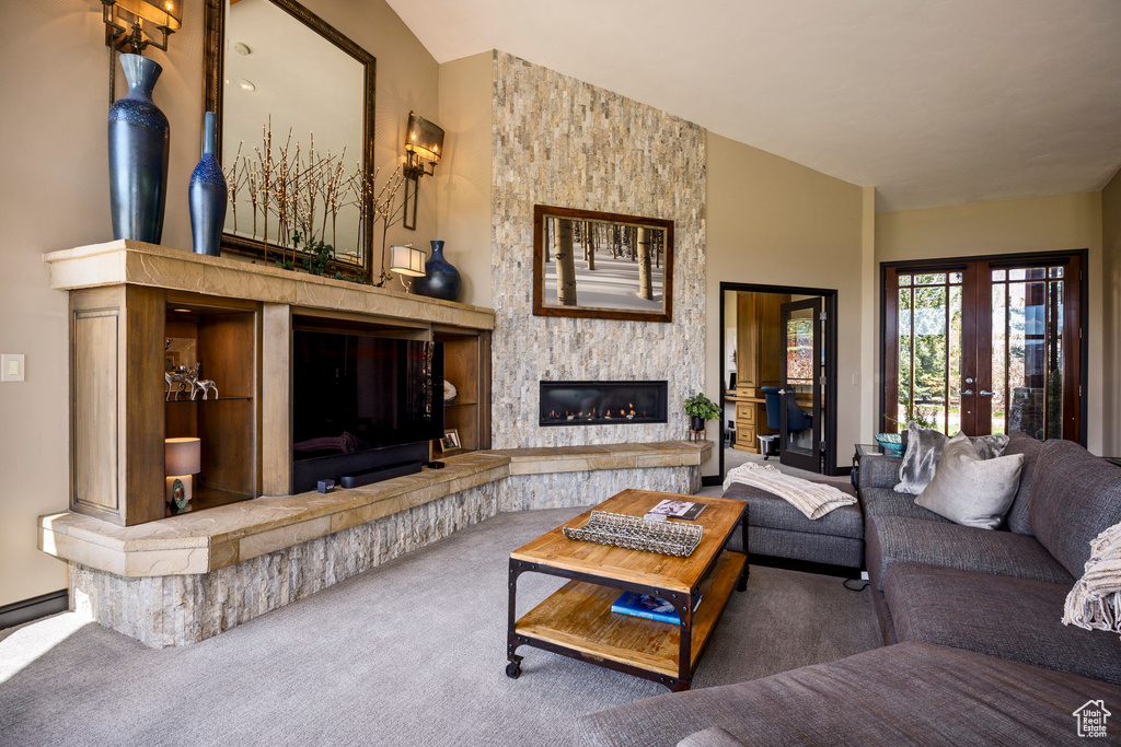 Carpeted living room featuring a fireplace and french doors