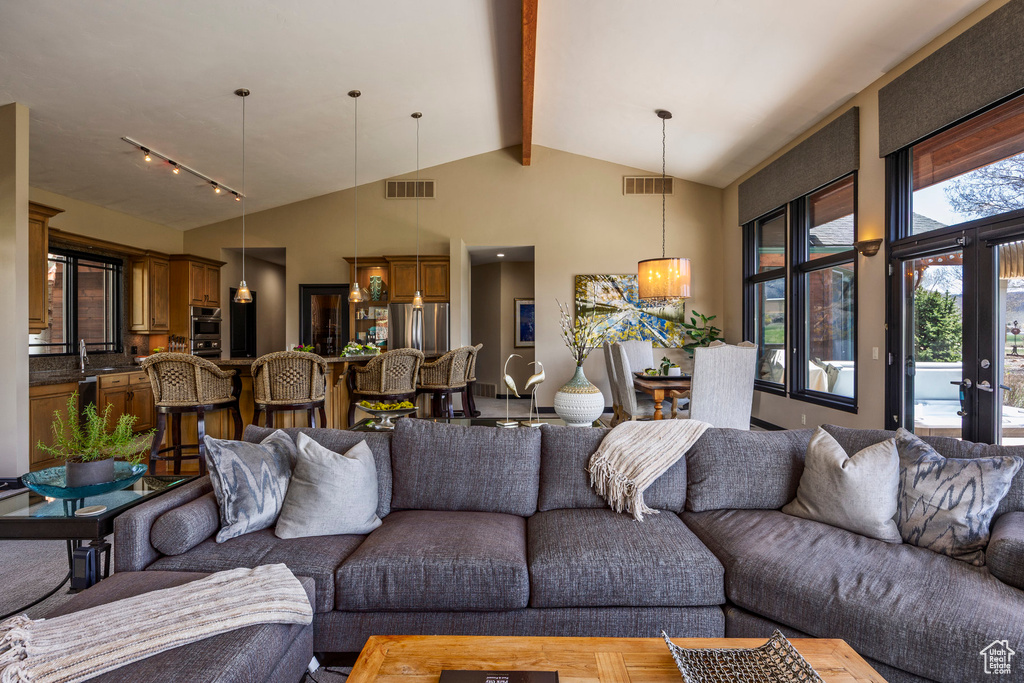 Living area featuring beamed ceiling, high vaulted ceiling, and track lighting