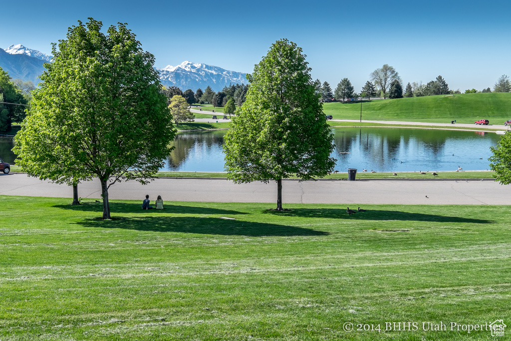 View of community featuring a water and mountain view and a lawn