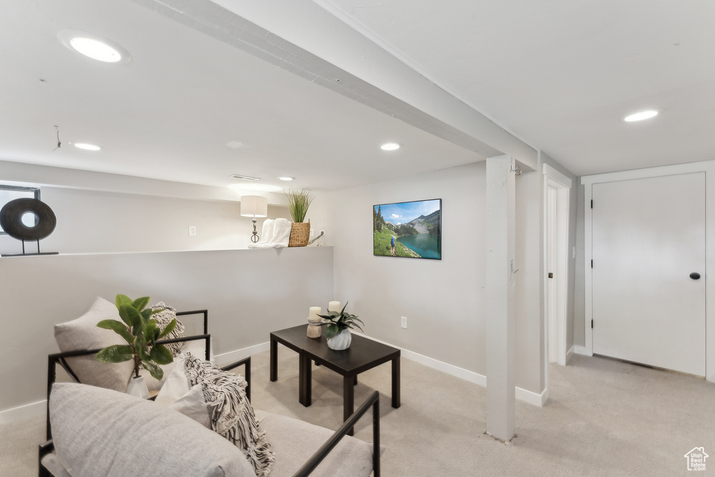 Living area featuring light colored carpet, baseboards, and recessed lighting