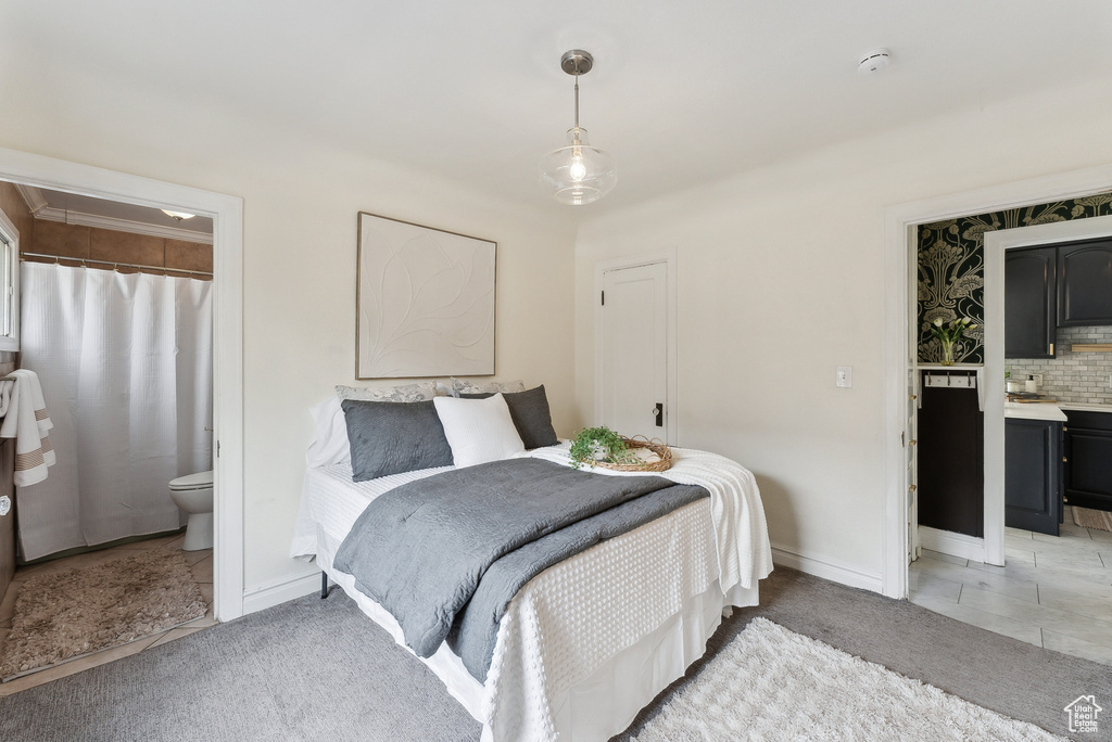 Bedroom featuring light carpet, connected bathroom, and baseboards