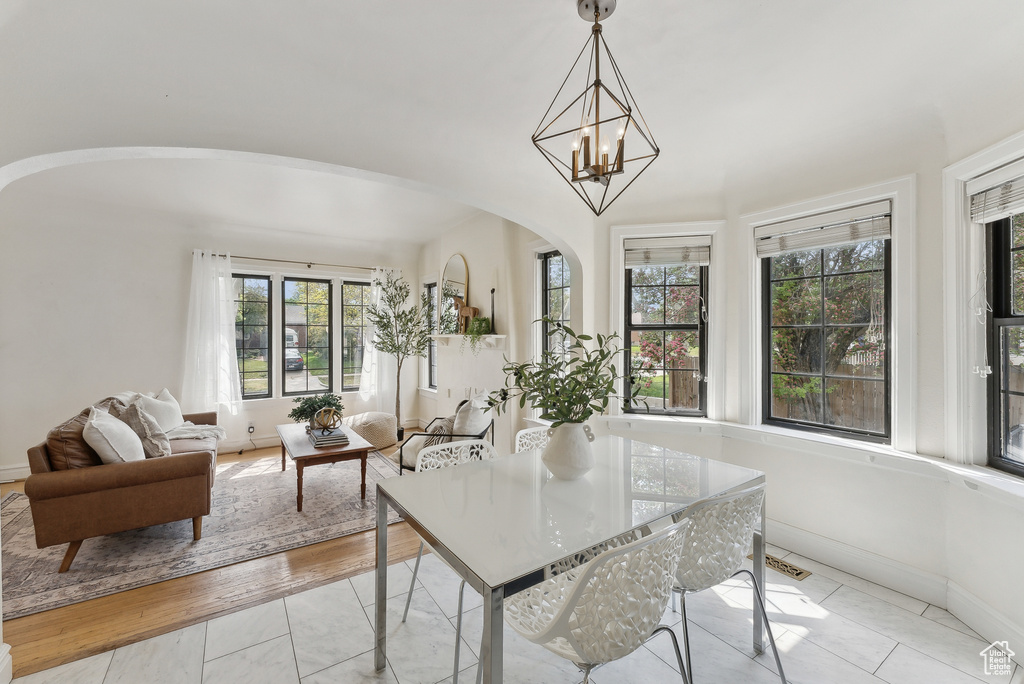 Dining area with an inviting chandelier, arched walkways, baseboards, and visible vents