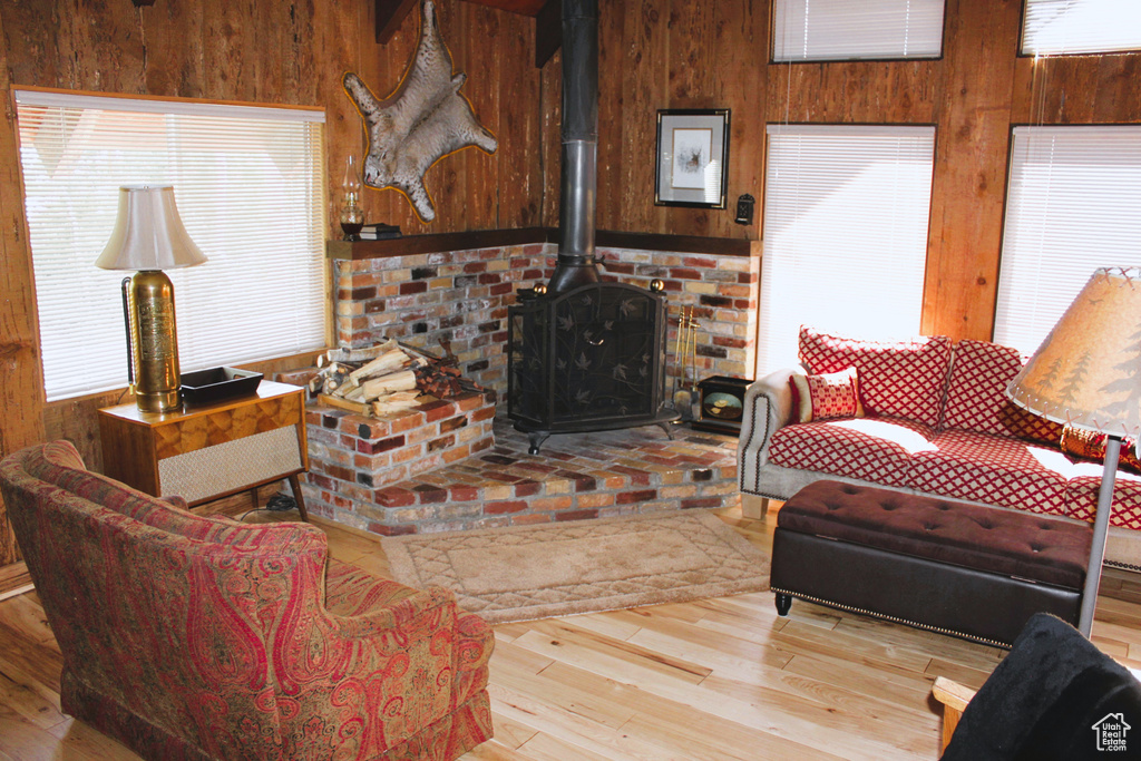 Living room with wood walls, hardwood / wood-style floors, and a wood stove