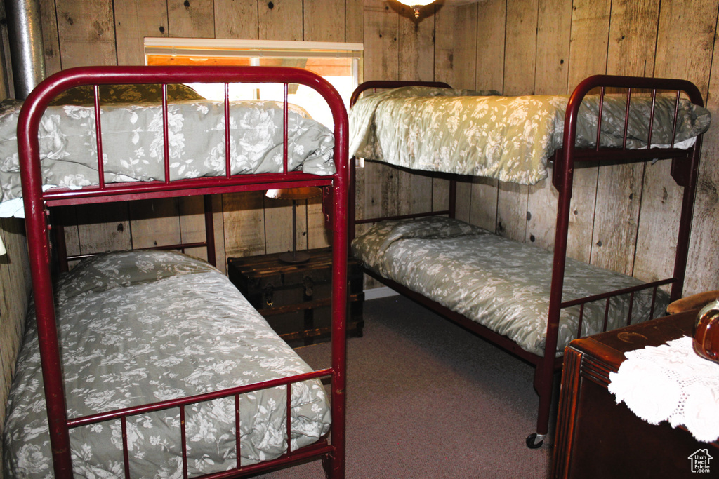 Bedroom with wood walls and carpet