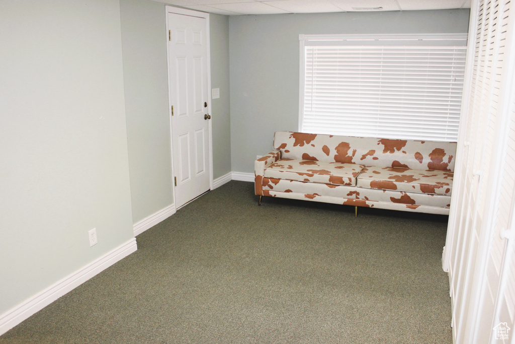 Unfurnished room featuring dark colored carpet and baseboards