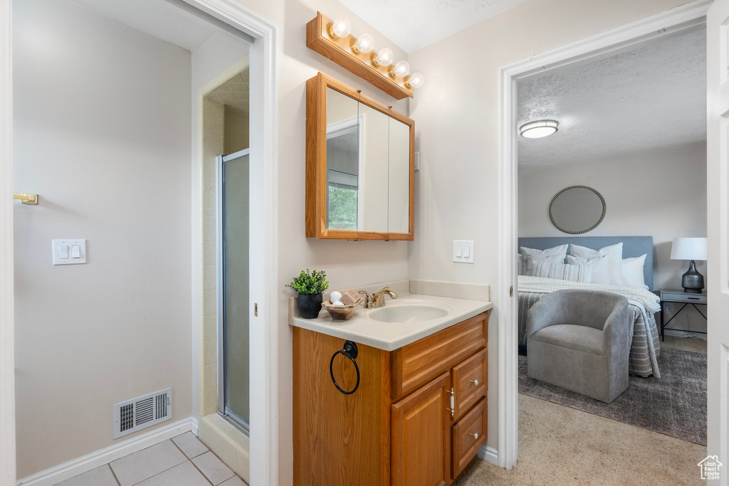 Full bathroom with ensuite bath, a stall shower, vanity, and baseboards