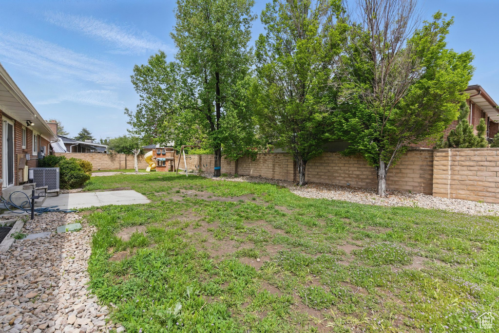 View of yard with central air condition unit, a patio, and a playground