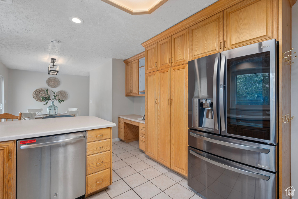 Kitchen featuring appliances with stainless steel finishes, a textured ceiling, light tile patterned flooring, light countertops, and recessed lighting