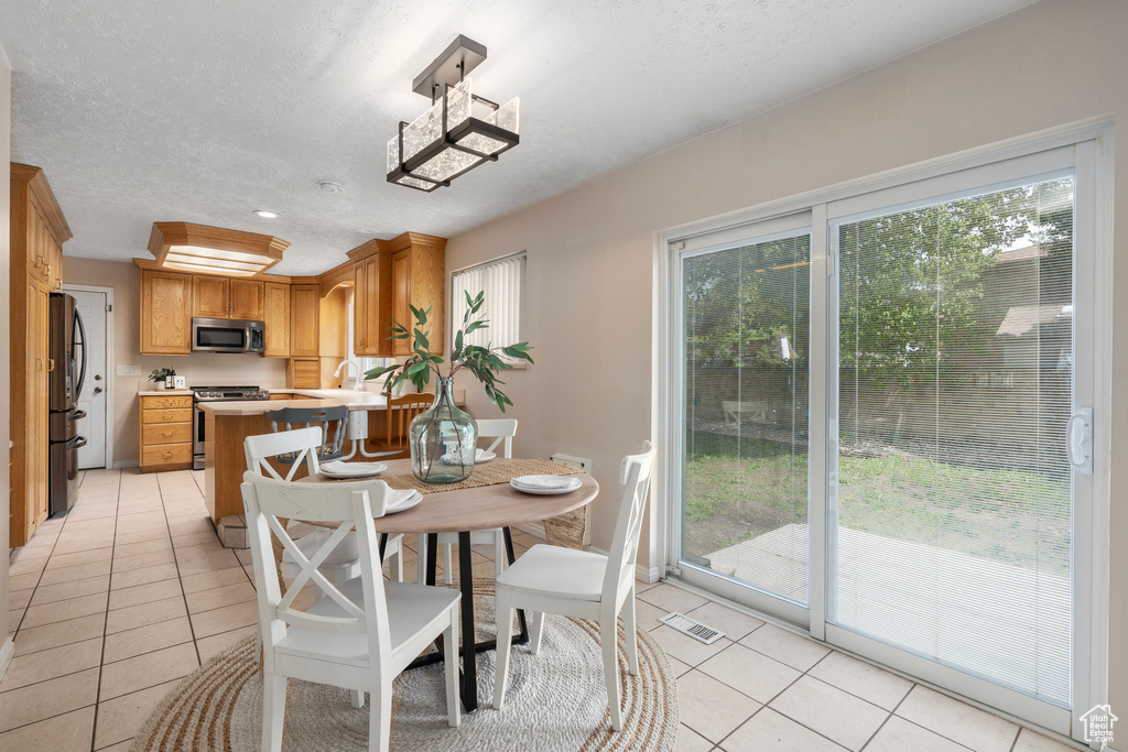 Dining space featuring light tile patterned floors and a textured ceiling