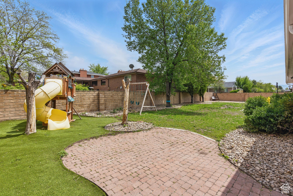 View of yard with a playground and a patio