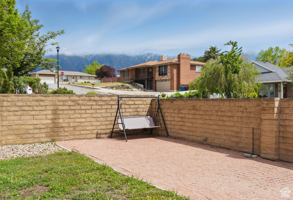 View of yard with a mountain view, fence, and a patio area