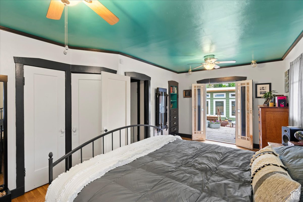 Bedroom featuring a ceiling fan, crown molding, and wood finished floors