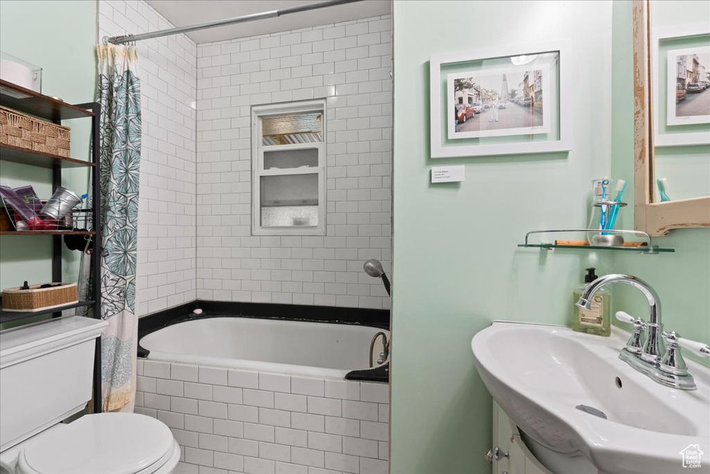 Bathroom featuring vanity, toilet, and tiled shower / bath