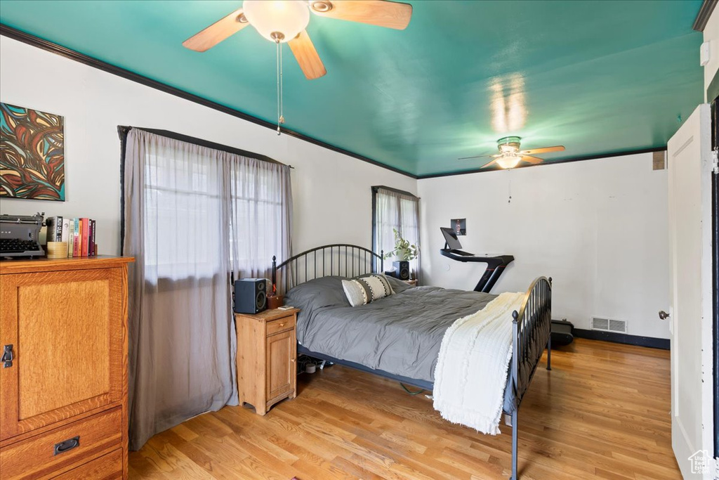 Bedroom featuring a ceiling fan, visible vents, and light wood-style floors