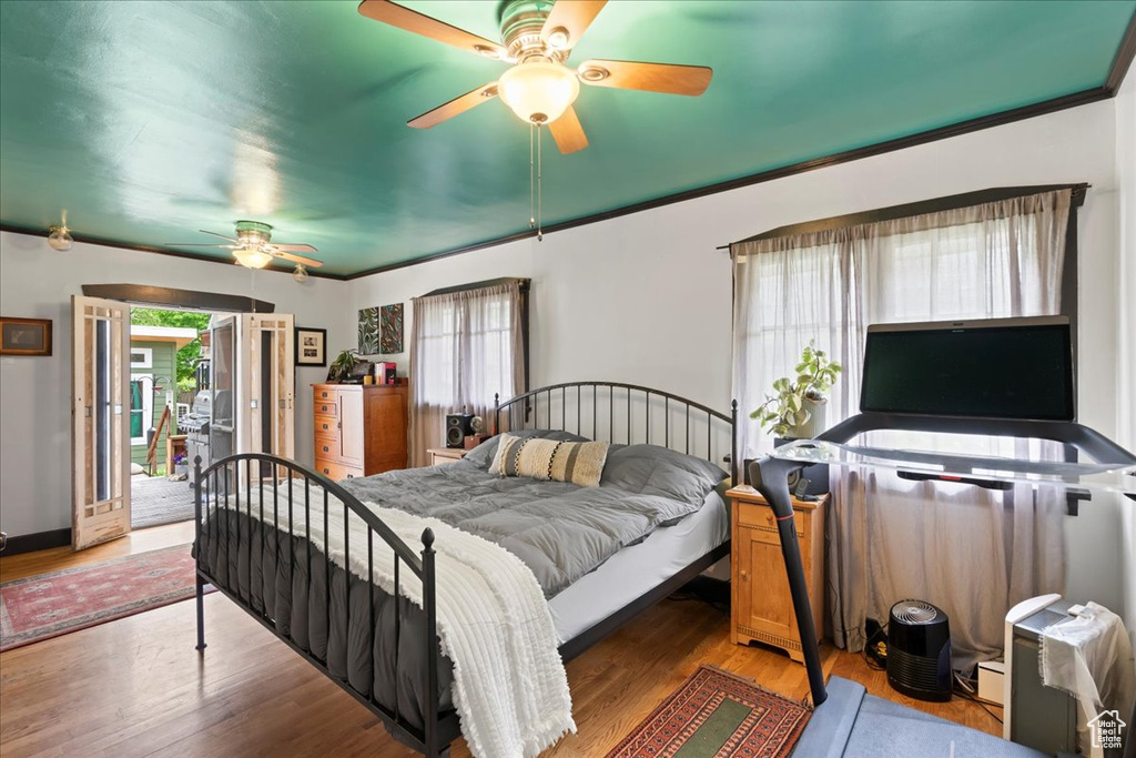 Bedroom with a ceiling fan, wood finished floors, and access to exterior