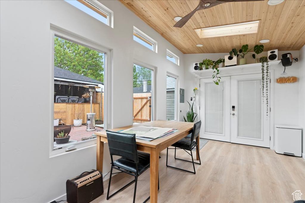 Dining room featuring a skylight, wood ceiling, and light wood-style flooring