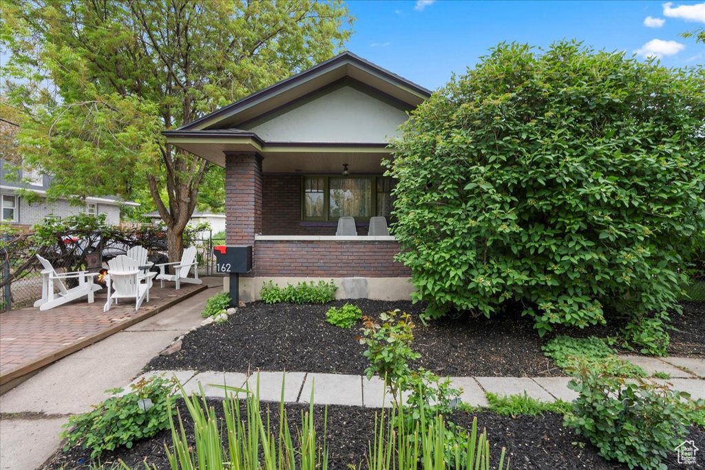 Bungalow-style home with a porch and brick siding