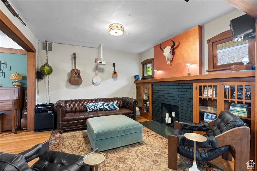 Living area with wood finished floors and a brick fireplace