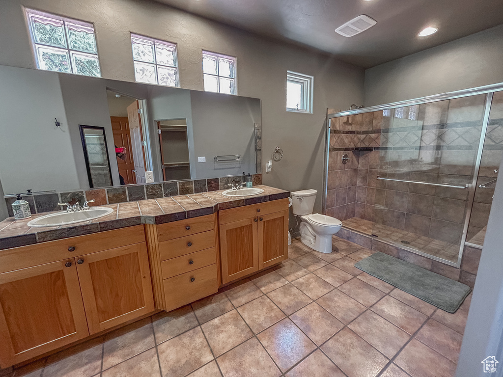 Full bathroom featuring a sink, toilet, a stall shower, and visible vents