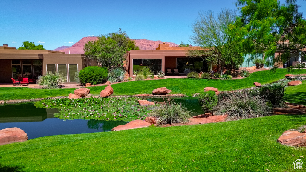 Back of house with a lawn and a mountain view