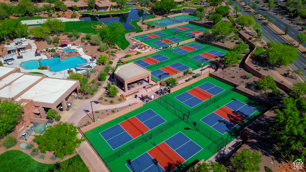 Drone / aerial view of a nearby body of water and a pool area