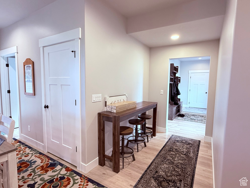 Corridor featuring light wood finished floors, baseboards, and recessed lighting