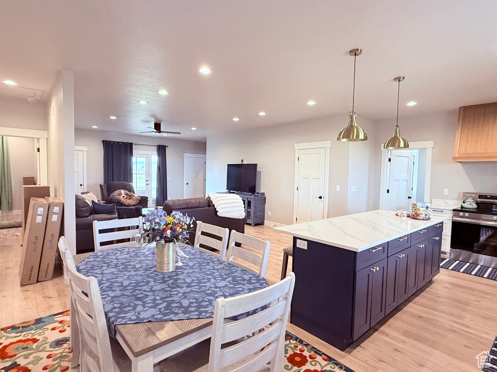 Kitchen featuring stainless steel electric range, light wood-type flooring, recessed lighting, a center island, and open floor plan