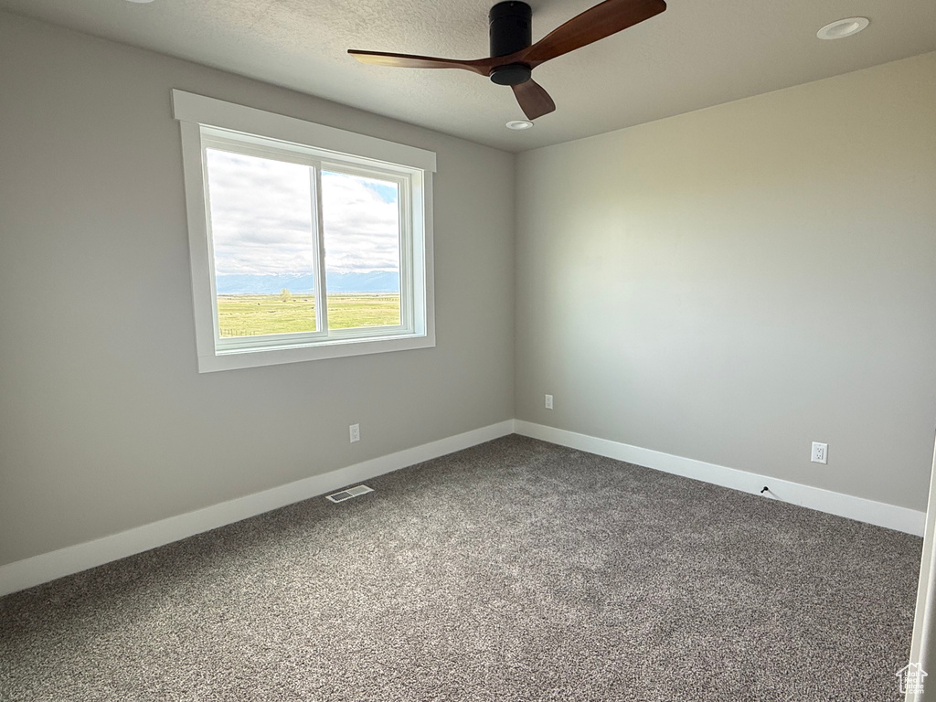 Spare room with ceiling fan, carpet, and baseboards