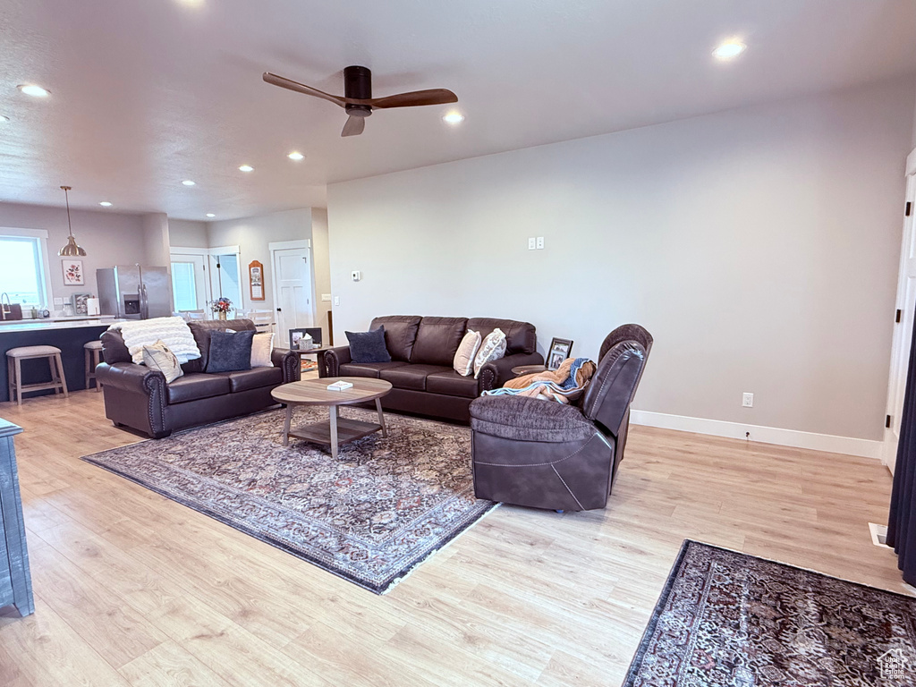 Living area featuring light wood-type flooring, a ceiling fan, recessed lighting, and baseboards