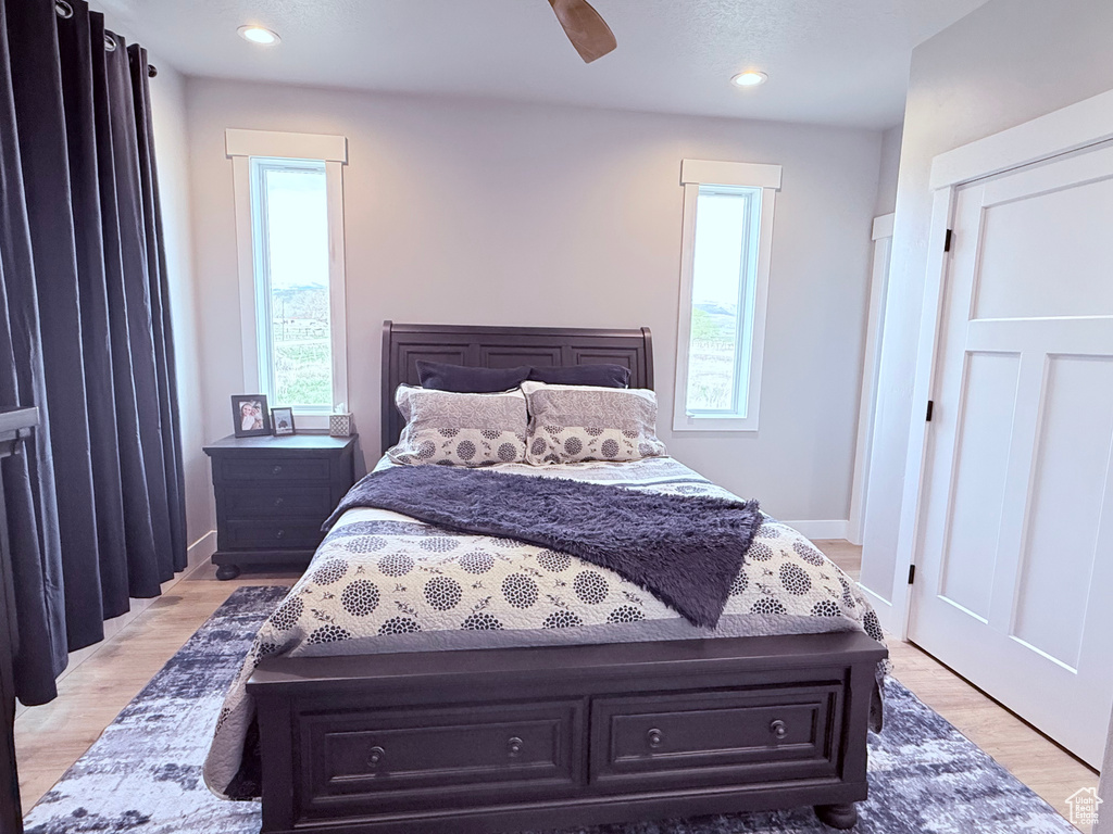Bedroom with light wood finished floors, a ceiling fan, recessed lighting, and baseboards