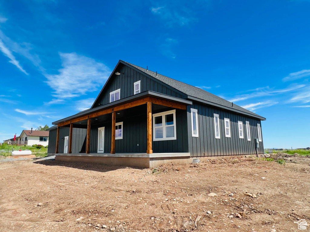 View of side of property featuring board and batten siding and covered porch