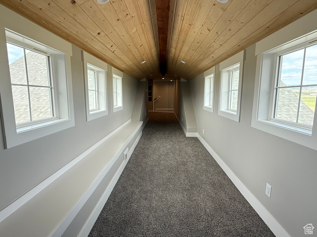 Hallway with carpet floors, wood ceiling, and baseboards