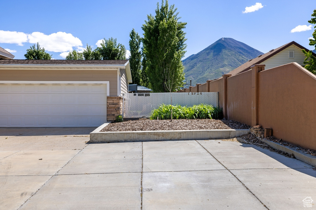 View of home\\\\\\\\\\\\\\\\\\\\\\\\\\\\\\\'s exterior featuring fence, a mountain view, stone siding, and a garage