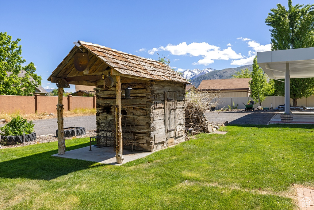View of yard featuring a patio, a mountain view, and an outbuilding