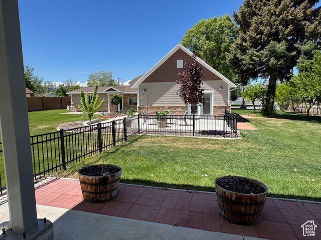 Back of property with a patio and stone siding