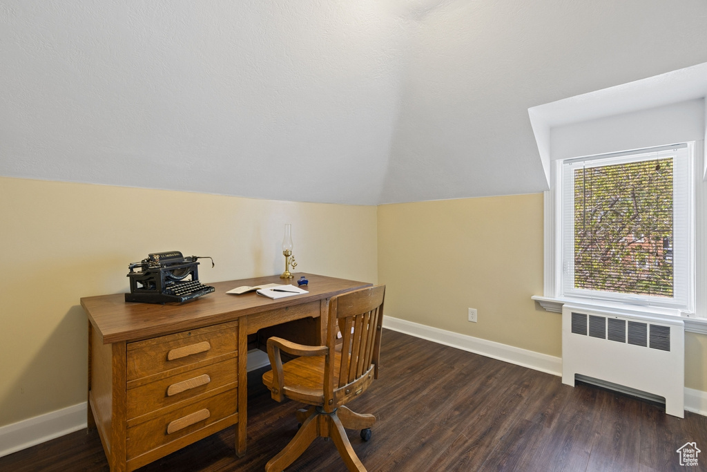 Home office featuring radiator, lofted ceiling, baseboards, and dark wood-style floors