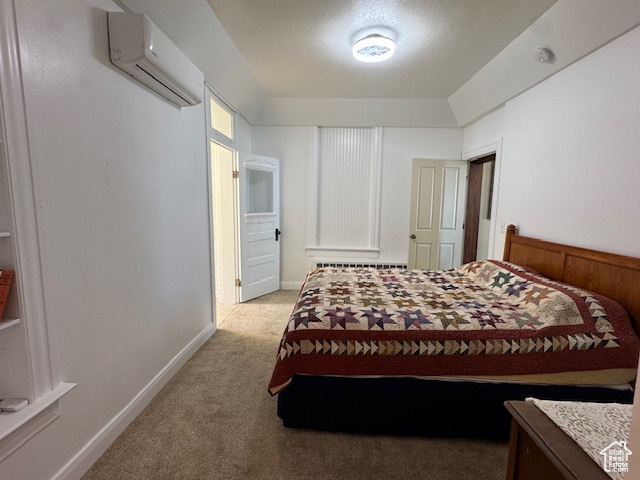 Bedroom featuring a wall mounted air conditioner and light colored carpet