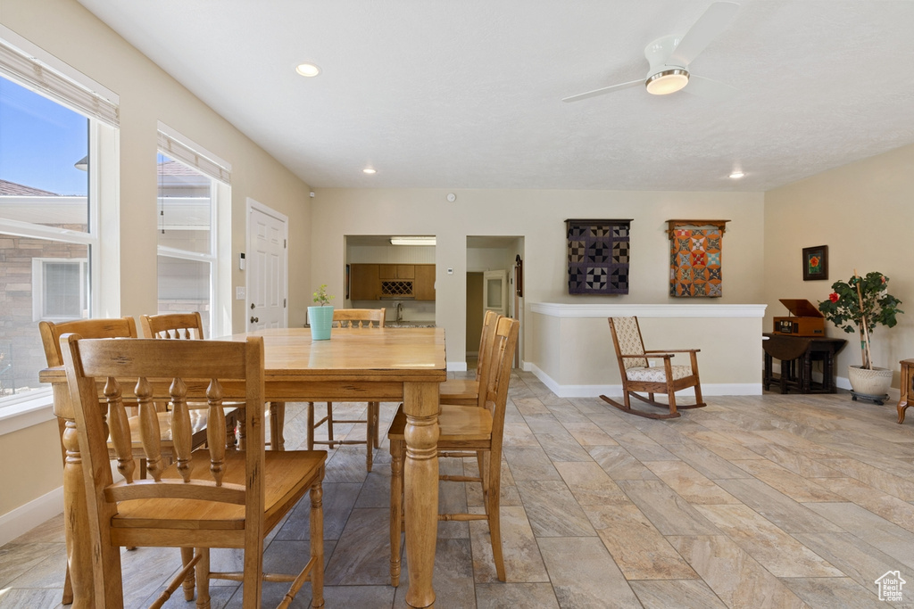 Dining area featuring ceiling fan, light stone finish flooring, baseboards, and recessed lighting