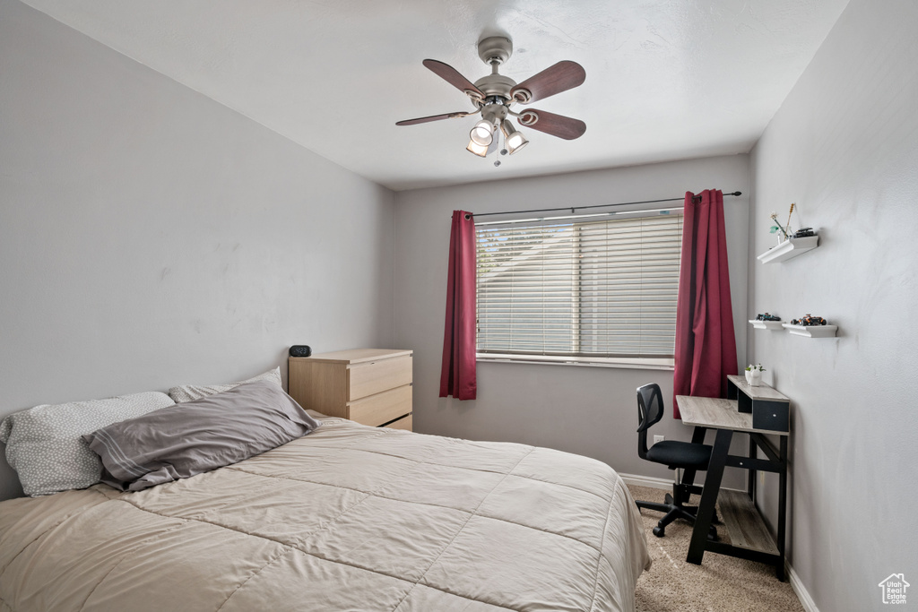 Carpeted bedroom featuring a ceiling fan and baseboards