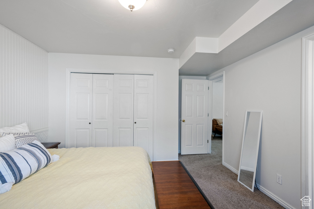 Bedroom featuring a closet, baseboards, and carpet flooring