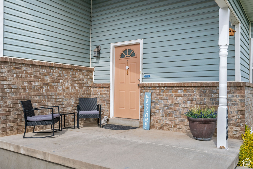 Doorway to property with a patio and brick siding