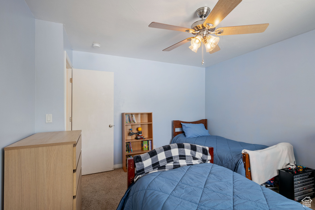 Carpeted bedroom featuring a ceiling fan and baseboards