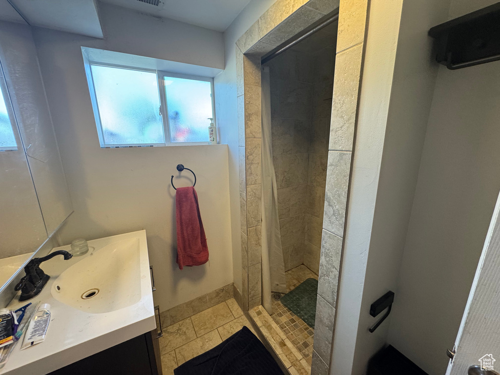 Full bath with a shower stall and vanity