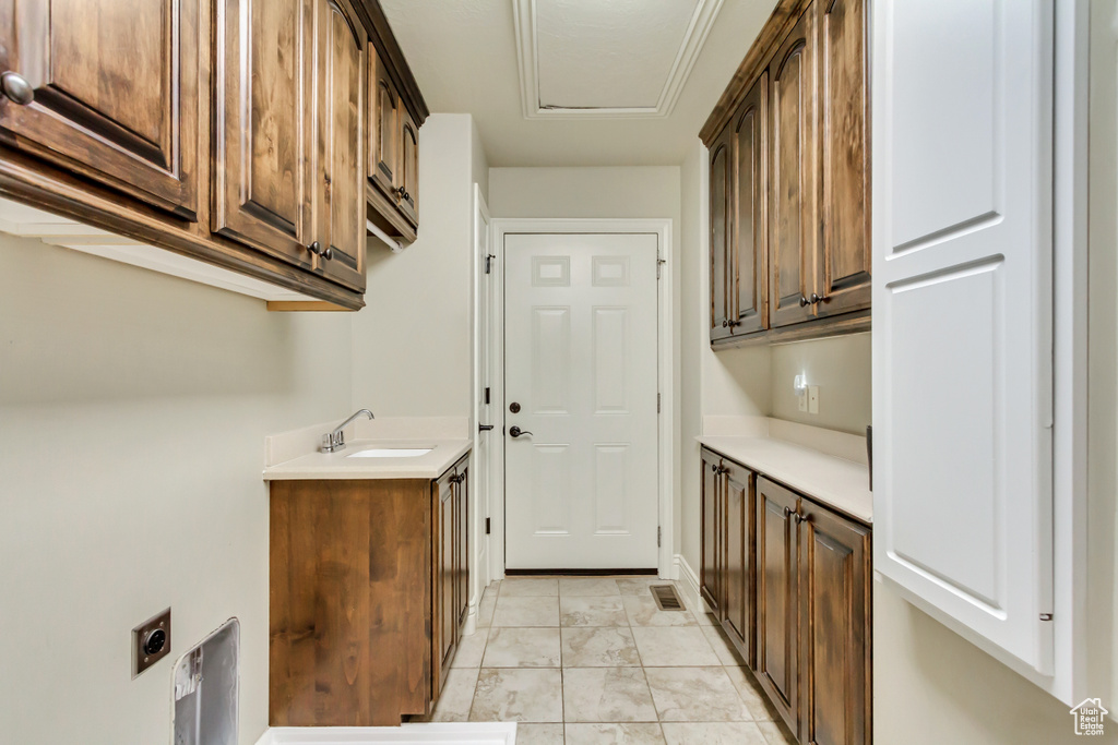 Laundry area with cabinet space, light marble finish floors, and electric dryer hookup