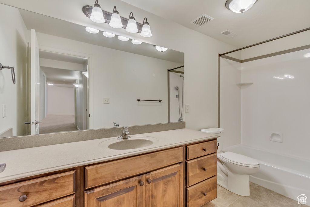 Full bathroom featuring toilet, tub / shower combination, vanity, and tile patterned floors