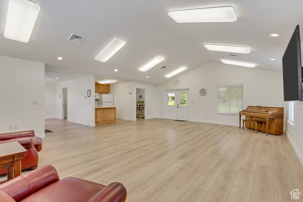 Living room with light wood-style floors, baseboards, vaulted ceiling, and recessed lighting