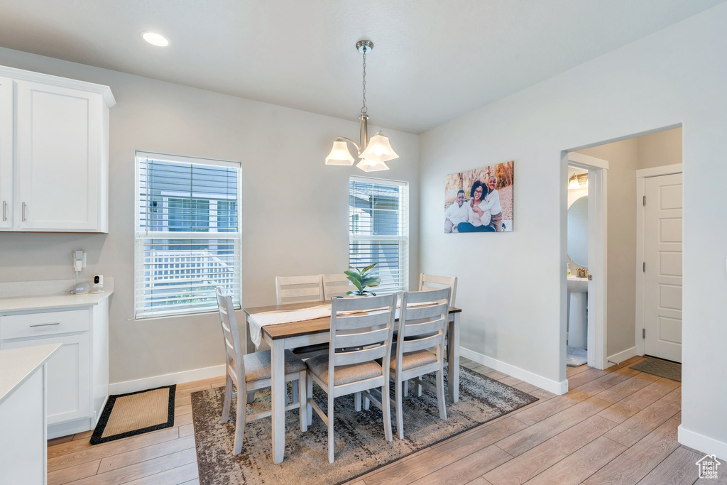 Dining area with light wood-type flooring, a chandelier, baseboards, and recessed lighting